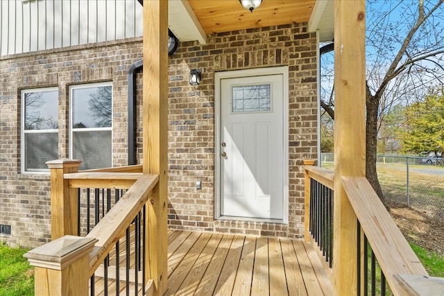 property entrance with brick siding and fence