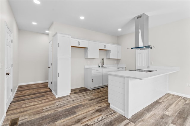 kitchen with visible vents, wood finished floors, exhaust hood, light countertops, and black electric stovetop