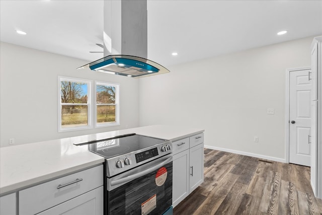 kitchen featuring dark wood-style floors, island exhaust hood, stainless steel range with electric cooktop, light countertops, and white cabinets