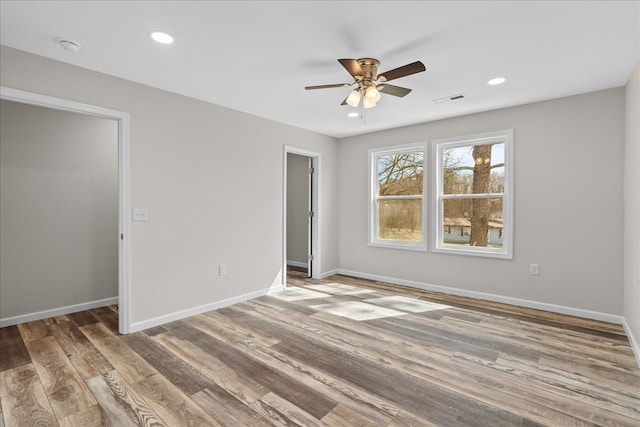 spare room with visible vents, baseboards, ceiling fan, and wood finished floors