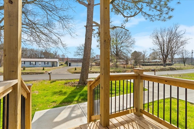 deck featuring a residential view, covered porch, and a yard