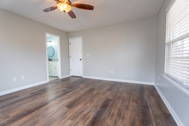 spare room with ceiling fan, a wealth of natural light, a textured ceiling, and dark hardwood / wood-style flooring