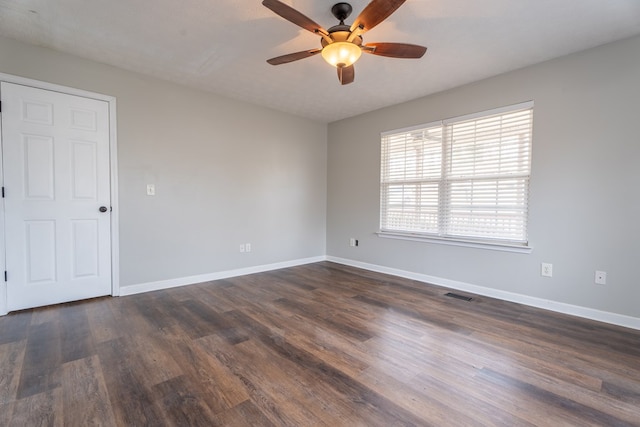 spare room with dark hardwood / wood-style flooring and ceiling fan