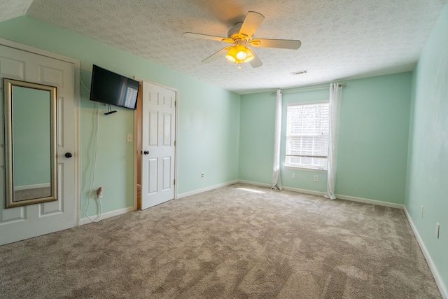 spare room with ceiling fan, carpet, and a textured ceiling