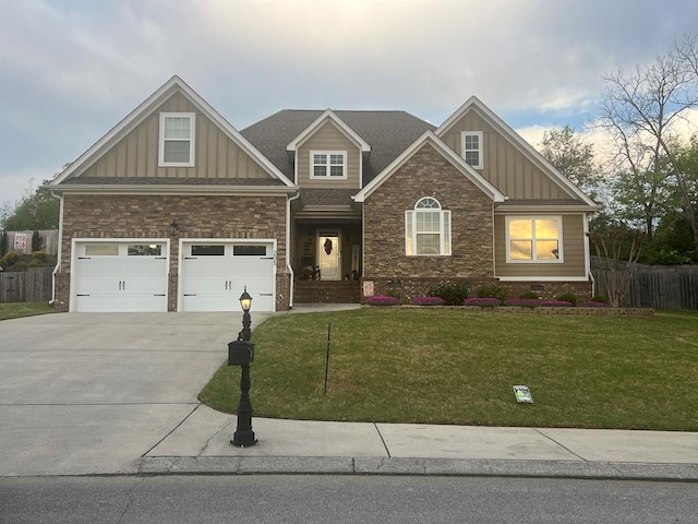 craftsman inspired home featuring board and batten siding, driveway, fence, and a front lawn