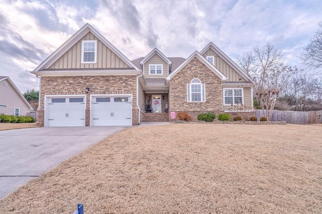 craftsman inspired home featuring board and batten siding, stone siding, fence, an attached garage, and concrete driveway