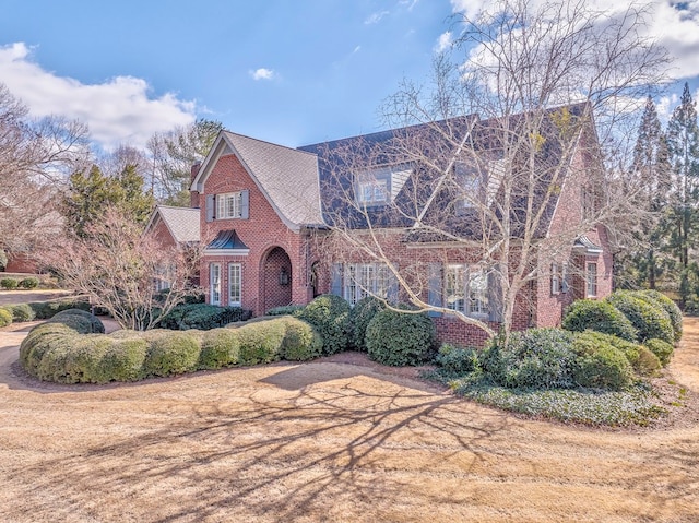 english style home featuring brick siding