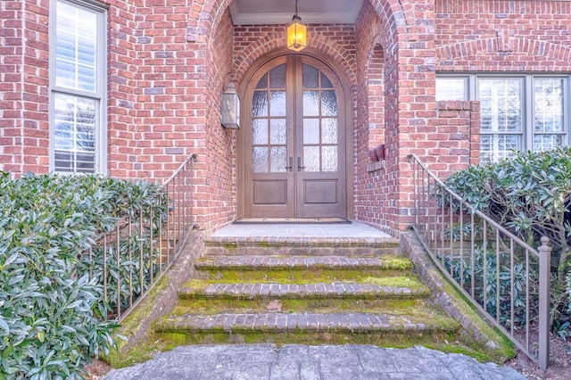 view of exterior entry with french doors and brick siding