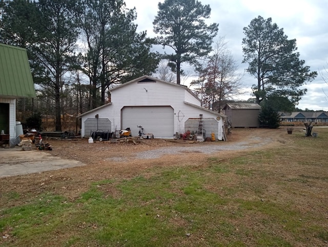 view of side of home with an outbuilding, a garage, and a lawn