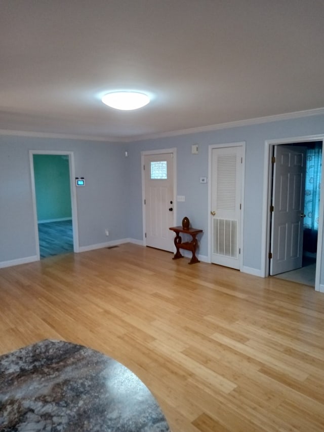 interior space featuring crown molding and light hardwood / wood-style floors