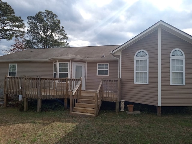 rear view of property with a yard and a deck