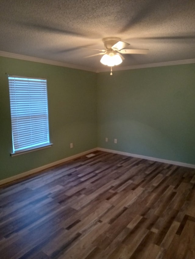 spare room featuring a textured ceiling, ornamental molding, dark hardwood / wood-style floors, and ceiling fan