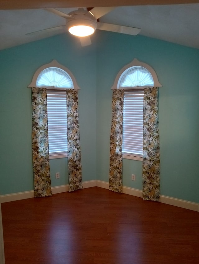 empty room featuring a wealth of natural light, dark hardwood / wood-style floors, and ceiling fan