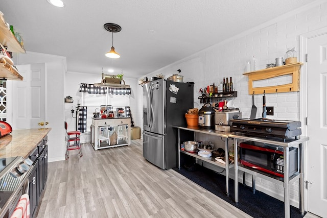 kitchen featuring pendant lighting, ornamental molding, light hardwood / wood-style floors, stainless steel refrigerator with ice dispenser, and a textured ceiling