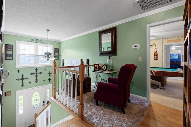 interior space featuring crown molding, ceiling fan, hardwood / wood-style floors, a textured ceiling, and pool table