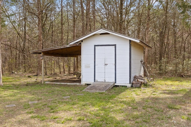 view of shed featuring a forest view and a carport