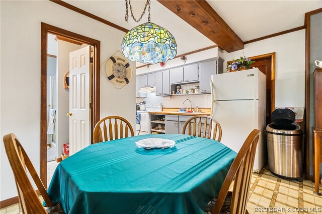 dining room featuring beamed ceiling, sink, and ornamental molding