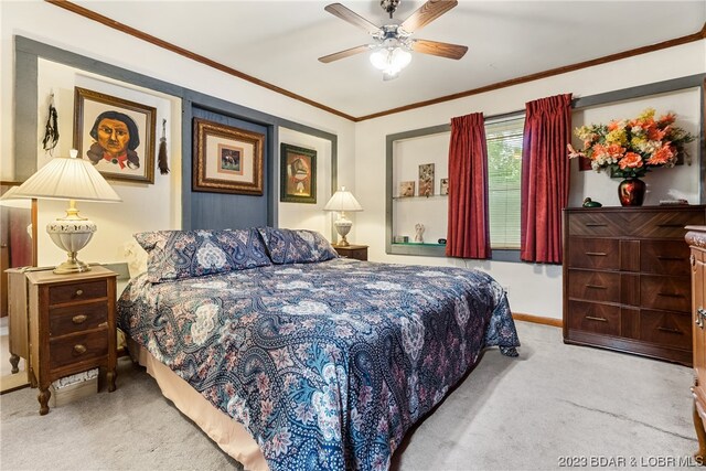 carpeted bedroom with ceiling fan and crown molding