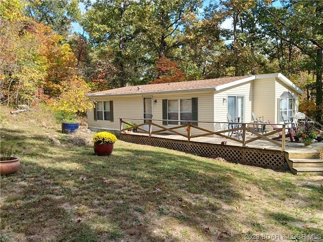 manufactured / mobile home with a front lawn and a wooden deck