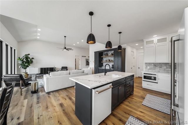 kitchen featuring pendant lighting, light wood-type flooring, white cabinets, an island with sink, and dishwasher