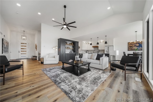 living room featuring high vaulted ceiling, light wood-type flooring, and ceiling fan