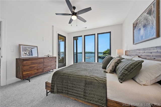 bedroom with a water view, access to outside, ceiling fan, and carpet floors