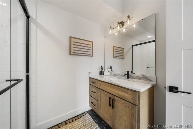 bathroom featuring a shower with shower door, vanity, and tile patterned floors