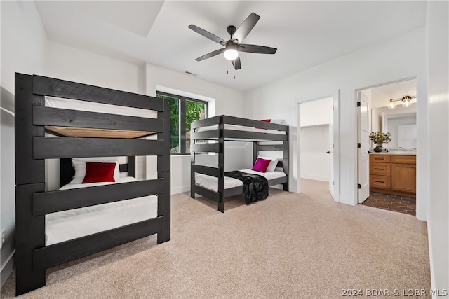 carpeted bedroom featuring ensuite bathroom and ceiling fan