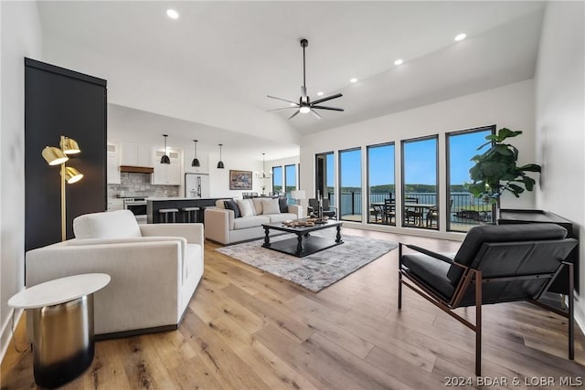 128 Palisades Yacht Club Dr, Lake Ozark, MO 65049 - living room featuring ceiling fan with notable chandelier, light hardwood / wood-style floors, and vaulted ceiling