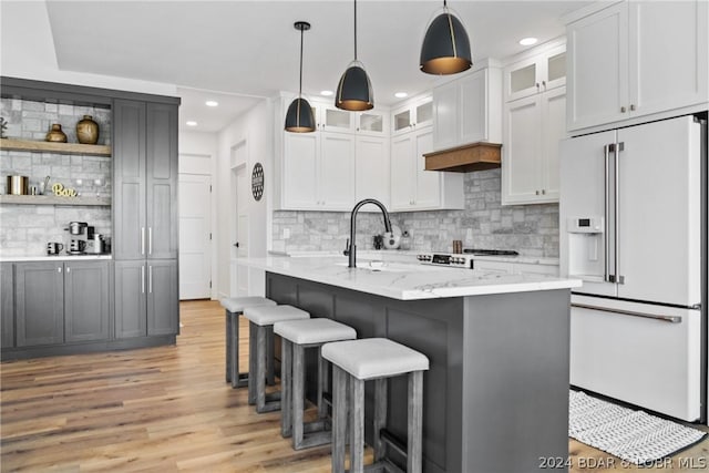 128 Palisades Yacht Club Dr, Lake Ozark, MO 65049 - kitchen with light stone countertops, pendant lighting, high end fridge, white cabinetry, and backsplash