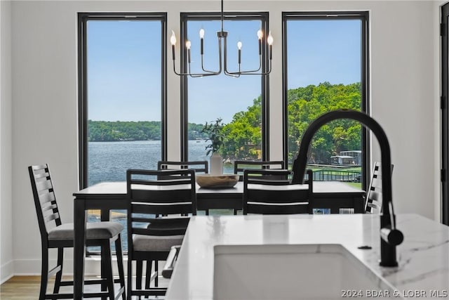 128 Palisades Yacht Club Dr, Lake Ozark, MO 65049 - dining area with sink, a wealth of natural light, a notable chandelier, and a water view