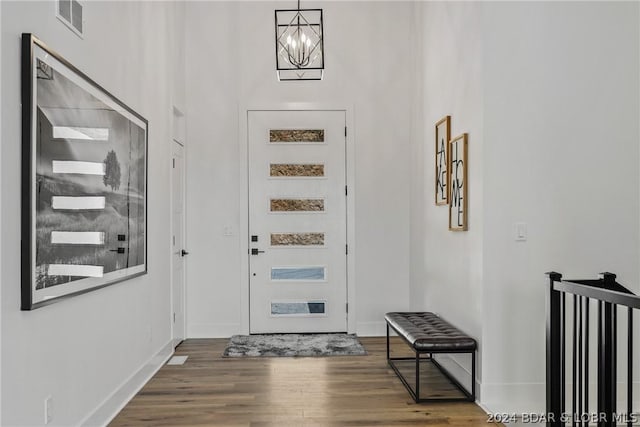 entryway featuring dark wood-type flooring and an inviting chandelier