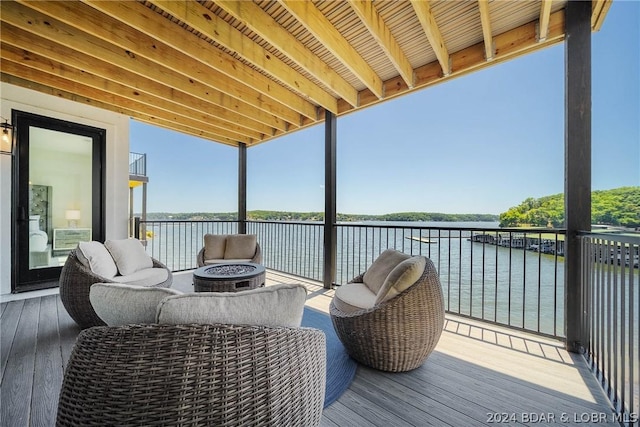 wooden terrace with a water view and an outdoor fire pit