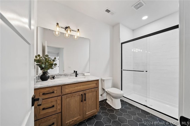 bathroom featuring toilet, tile patterned floors, walk in shower, and vanity