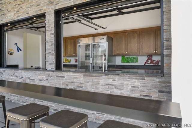 kitchen with high end fridge, a breakfast bar, and sink