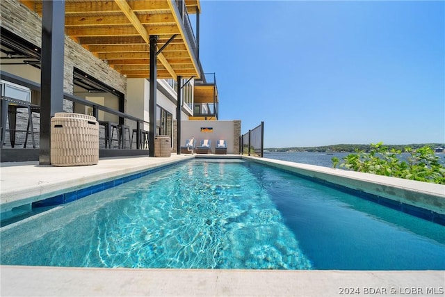 view of swimming pool featuring a water view