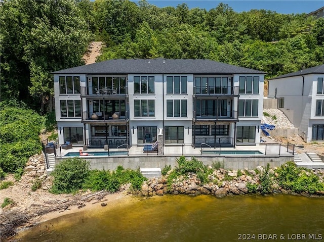 rear view of house with a patio and a water view