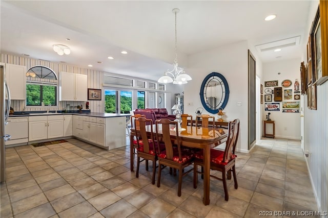 dining room with an inviting chandelier, sink, and light tile floors