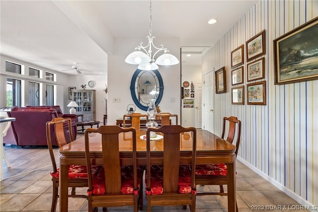 tiled dining space featuring ceiling fan with notable chandelier