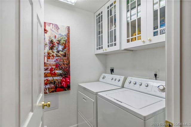 washroom with cabinets and washer and clothes dryer