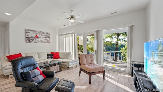 living room featuring light hardwood / wood-style floors and ceiling fan