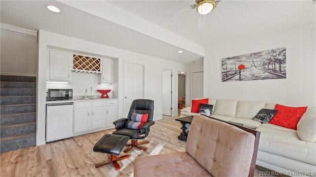 living room featuring indoor wet bar, light hardwood / wood-style floors, and ceiling fan