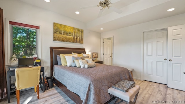 bedroom with a closet, light hardwood / wood-style floors, and ceiling fan