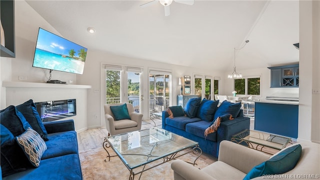 living room with ceiling fan with notable chandelier, light wood-type flooring, a healthy amount of sunlight, and french doors