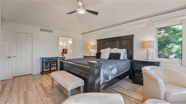 bedroom with vaulted ceiling, ceiling fan, light hardwood / wood-style floors, and ensuite bath