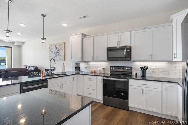 kitchen featuring sink, stainless steel appliances, white cabinets, and hanging light fixtures