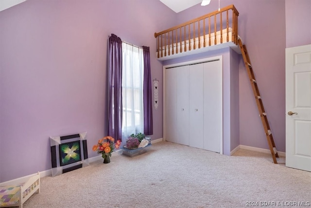 interior space with light colored carpet, a high ceiling, and a wealth of natural light