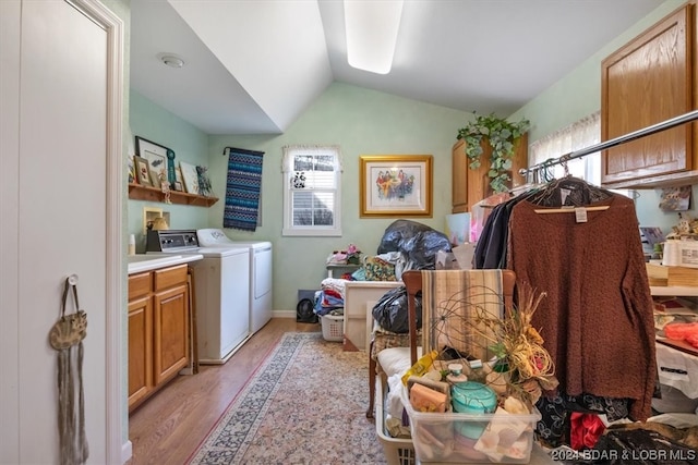 miscellaneous room with separate washer and dryer, lofted ceiling, a healthy amount of sunlight, and light hardwood / wood-style flooring