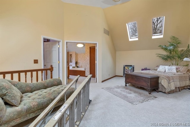 bedroom featuring high vaulted ceiling, light colored carpet, ensuite bath, and a skylight