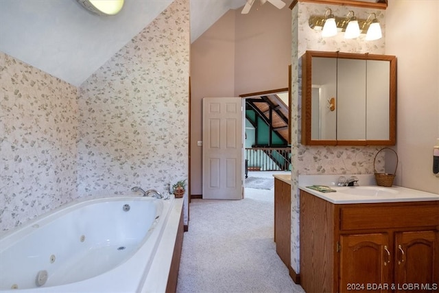 bathroom with lofted ceiling, ceiling fan, vanity, and a washtub